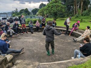 A park ranger conducts a morning briefing session for a small group of international tourists before a gorilla trekking expedition in Rwanda.